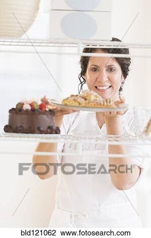 Hispanic baker holding fresh desserts View Large Photo Image Stock Image - Hispanic baker holding fresh desserts. Fotosearch
