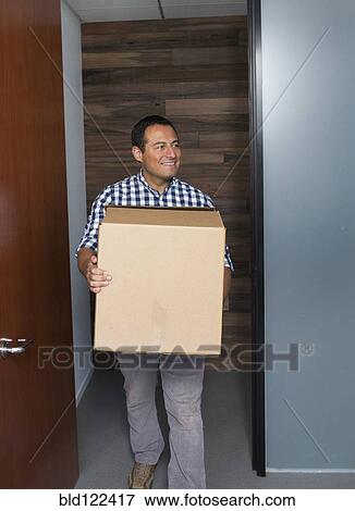 Hispanic businessman carrying cardboard box in office View Large Photo Image Stock Photo - Hispanic businessman carrying cardboard box in office. Fotosearch