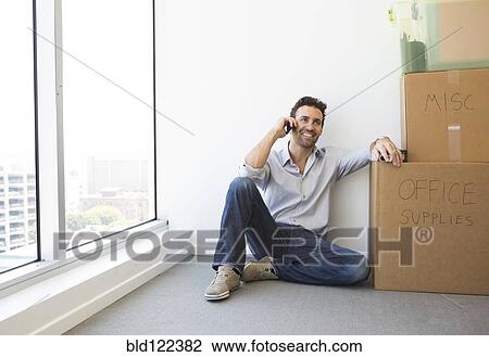 Hispanic businessman on cell phone in new office View Large Photo Image Stock Image - Hispanic businessman on cell phone in new office. Fotosearch