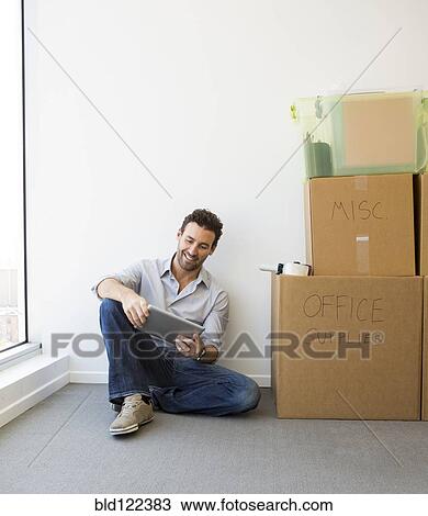 Hispanic businessman using digital tablet in new office View Large Photo Image Stock Image - Hispanic businessman using digital tablet in new office. Fotosearch