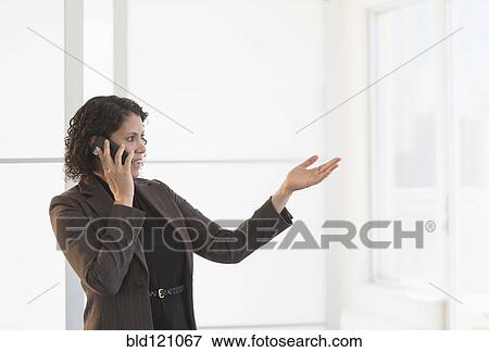 Stock Photo - Hispanic businesswoman talking on cell phone. Fotosearch