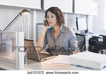 Stock Image - Hispanic businesswoman working in office. Fotosearch