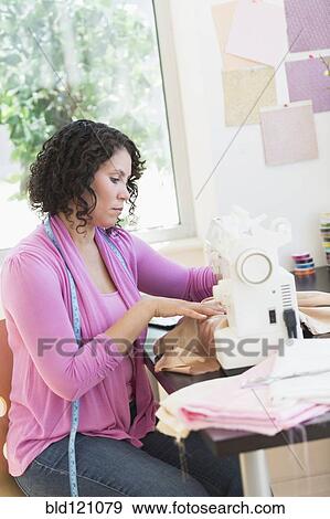 Hispanic dressmaker working at sewing machine View Large Photo Image Stock Photo - Hispanic dressmaker working at sewing machine. Fotosearch