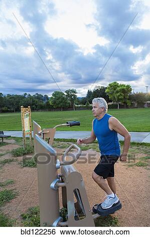 Stock Photograph - Hispanic man exercising in park. Fotosearch