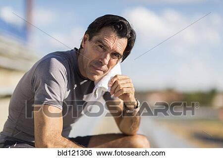 Hispanic man resting with towel around neck View Large Photo Image Stock Photograph - Hispanic man resting with towel around neck. Fotosearch