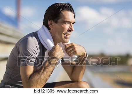 Hispanic man resting with towel around neck View Large Photo Image Stock Photography - Hispanic man resting with towel around neck. Fotosearch