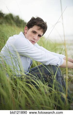 Hispanic man sitting in tall grass View Large Photo Image Stock Image - Hispanic man sitting in tall grass. Fotosearch