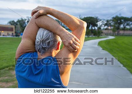 Stock Photography - Hispanic man stretching in park. Fotosearch