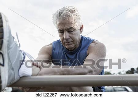 Stock Photo - Hispanic man stretching outdoors. Fotosearch