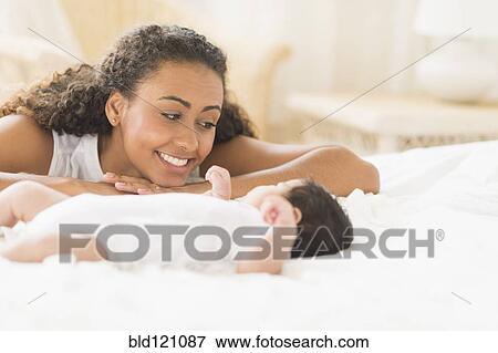 Stock Photo - Hispanic mother admiring baby. Fotosearch