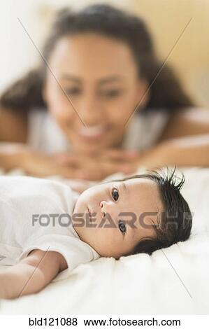 Stock Photo - Hispanic mother admiring baby. Fotosearch