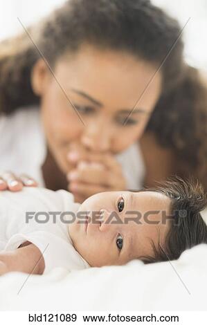 Stock Photo - Hispanic mother admiring baby. Fotosearch