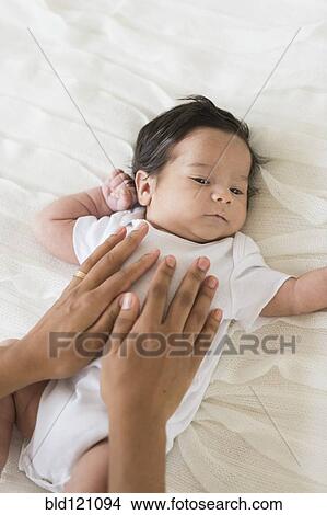 Picture - Hispanic mother cradling baby. Fotosearch