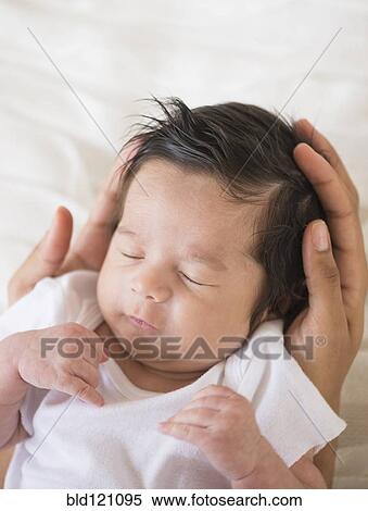 Stock Photography - Hispanic mother cradling baby. Fotosearch