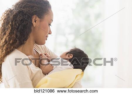Hispanic mother holding newborn baby View Large Photo Image Stock Photograph - Hispanic mother holding newborn baby. Fotosearch