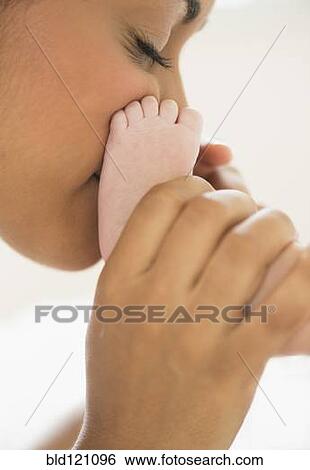 Hispanic mother kissing baby's feet View Large Photo Image Stock Photograph - Hispanic mother kissing baby's feet. Fotosearch