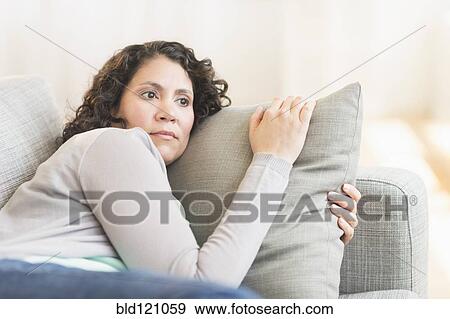 Stock Photo - Hispanic woman relaxing on sofa. Fotosearch