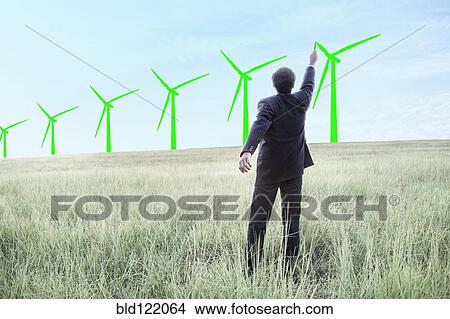 Indian businessman drawing wind turbines on sky View Large Photo Image Picture - Indian businessman drawing wind turbines on sky. Fotosearch