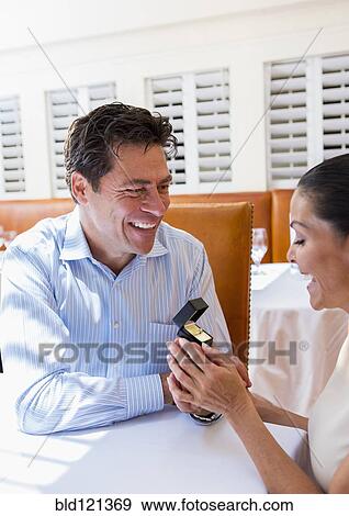 Stock Photo - Man proposing to girlfriend in restaurant. Fotosearch