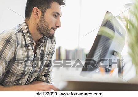 Stock Image - Mixed race businessman working in office. Fotosearch