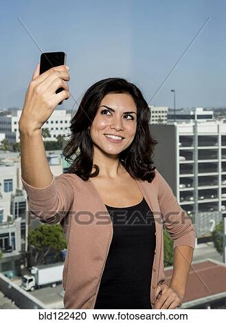 Mixed race businesswoman taking cell phone picture View Large Photo Image Stock Image - Mixed race businesswoman taking cell phone picture. Fotosearch