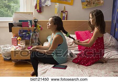 Mixed race girl braiding sister's hair View Large Photo Image Stock Image - Mixed race girl braiding sister's hair. Fotosearch