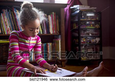 Stock Photograph - Mixed race girl drawing in living room. Fotosearch