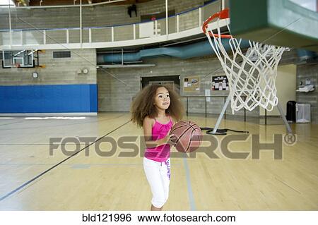 Mixed race girl playing basketball on court View Large Photo Image Stock Photograph - Mixed race girl playing basketball on court. Fotosearch
