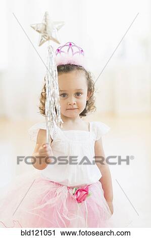 Stock Image - Mixed race girl playing dress up. Fotosearch