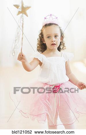 Stock Image - Mixed race girl playing dress up. Fotosearch