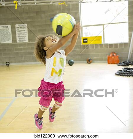 Mixed race girl playing with volleyball on court View Large Photo Image Stock Image - Mixed race girl playing with volleyball on court. Fotosearch