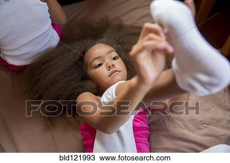 Mixed race girl pulling on sock View Large Photo Image Stock Image - Mixed race girl pulling on sock. Fotosearch