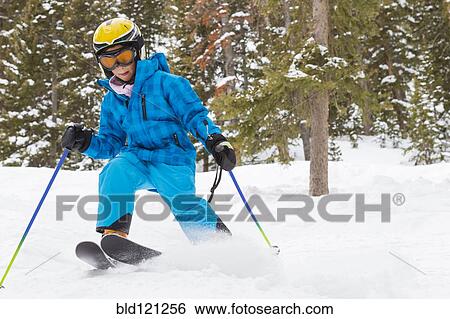 Stock Photograph - Mixed race girl skiing on snowy slope. Fotosearch