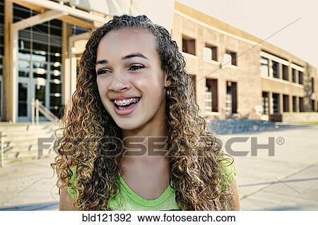 Stock Image - Mixed race girl smiling outdoors. Fotosearch