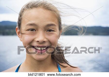 Stock Image - Mixed race girl smiling. Fotosearch