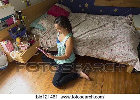 Stock Image - Mixed race girl using digital tablet. Fotosearch