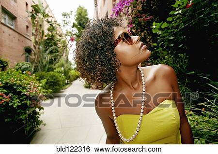 Stock Photograph - Mixed race girl walking in courtyard. Fotosearch