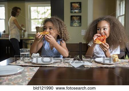 Mixed race girls eating pizza at table View Large Photo Image Stock Image - Mixed race girls eating pizza at table. Fotosearch