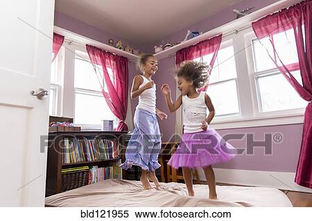 Mixed race girls jumping on bed View Large Photo Image Stock Photography - Mixed race girls jumping on bed. Fotosearch