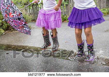 Mixed race girls playing in puddles View Large Photo Image Stock Photo - Mixed race girls playing in puddles. Fotosearch