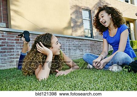 Mixed race girls talking in grass View Large Photo Image Stock Photo - Mixed race girls talking in grass. Fotosearch