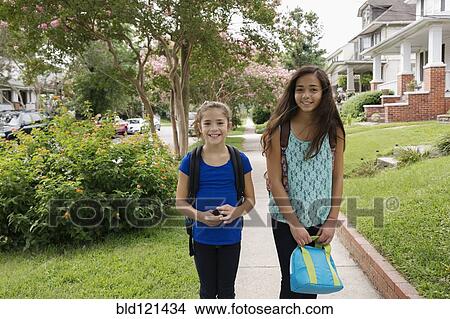 Picture - Mixed race girls walking to school. Fotosearch