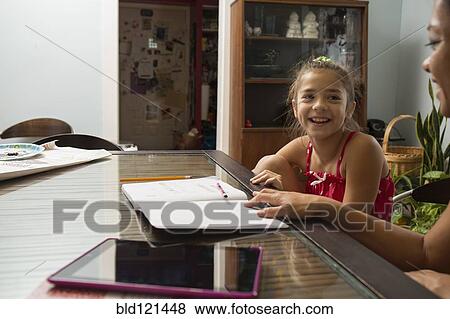 Mixed race mother helping daughter do homework View Large Photo Image Stock Photo - Mixed race mother helping daughter do homework. Fotosearch