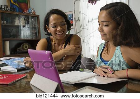 Mixed race mother helping daughter with homework View Large Photo Image Picture - Mixed race mother helping daughter with homework. Fotosearch