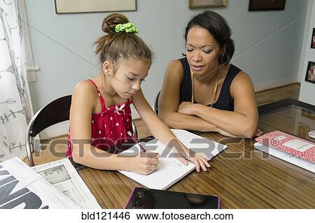 Mixed race mother helping daughter with homework View Large Photo Image Stock Photograph - Mixed race mother helping daughter with homework. Fotosearch