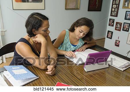 Mixed race mother helping daughter with homework View Large Photo Image Stock Photography - Mixed race mother helping daughter with homework. Fotosearch