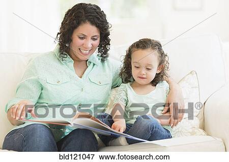 Mixed race mother reading with daughter View Large Photo Image Stock Photo - Mixed race mother reading with daughter. Fotosearch