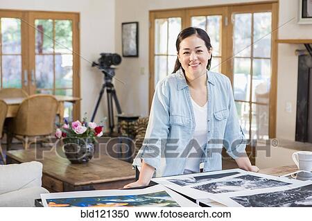 Stock Image - Mixed race photographer examining photographs. Fotosearch