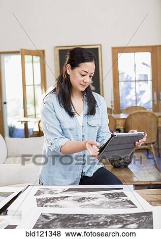 Stock Photo - Mixed race photographer using digital tablet. Fotosearch
