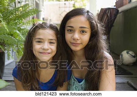 Mixed race sisters sitting outdoors View Large Photo Image Stock Image - Mixed race sisters sitting outdoors. Fotosearch